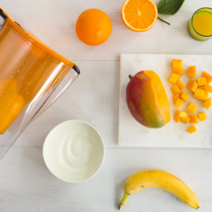 Ingredients for a Mango and Orange Smoothie made with Magnesium Mineralized Water for summer
