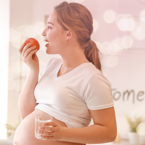 Pregnant woman drinking a glass of water